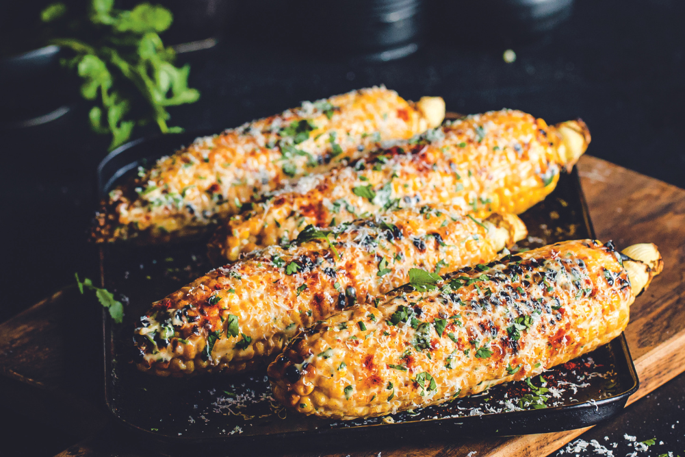 Photo d’un épi de maïs grillé avec mayonnaise, fromage et piment.