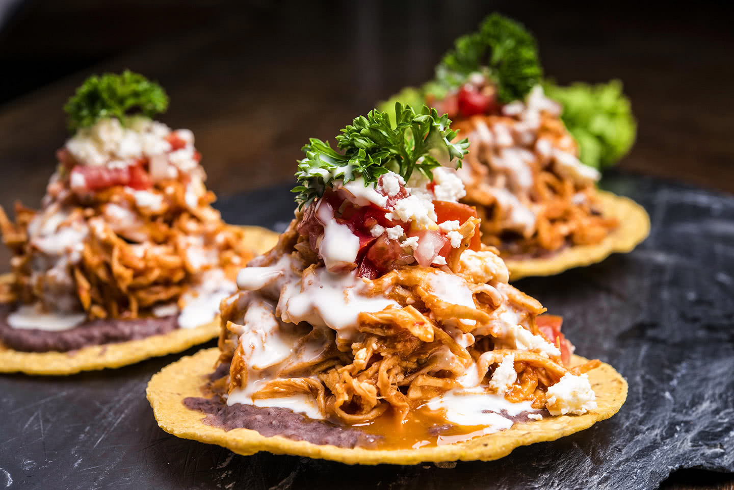 Tostadas croustillantes garnies de viande, légumes et crème.